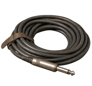 Aufgerolltes schwarzes Instrumentenkabel mit Klinkenstecker, der Gummimantel altersrissig